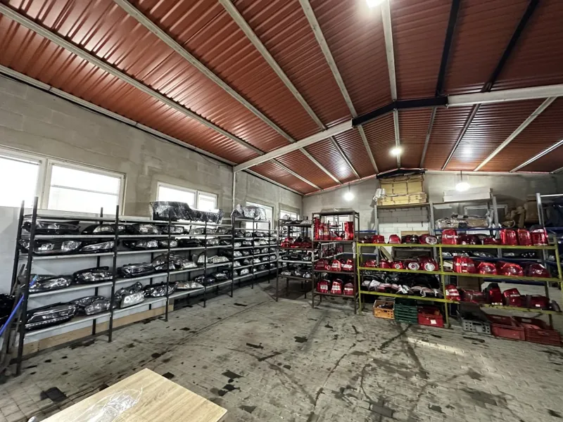 Uskladněné světlomety, nárazníky a další díly karoserie v regálech